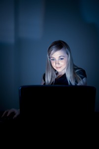 Young businesswoman with laptop at night