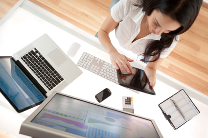 Businesswoman at her desk using a digital tablet shot from above with screen showing graphs and charts