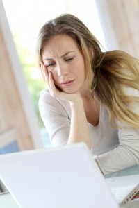 Active woman in front of laptop with upset look